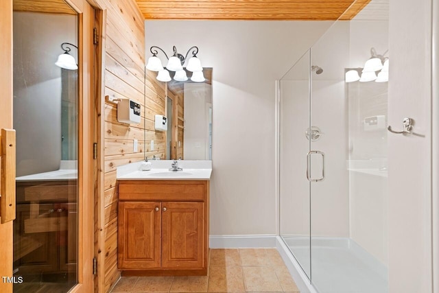 bathroom featuring tile patterned flooring, vanity, wooden walls, and walk in shower