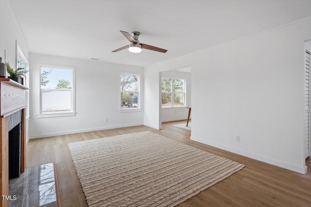 unfurnished living room with ornamental molding, light hardwood / wood-style floors, and ceiling fan