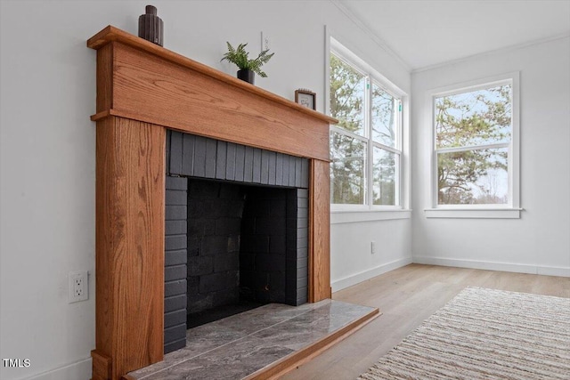 interior details with wood-type flooring and a brick fireplace