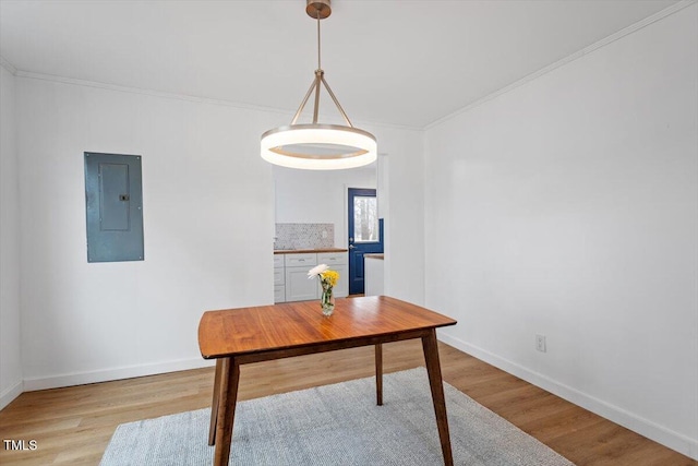 dining room with ornamental molding, electric panel, and light wood-type flooring