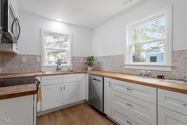 kitchen with white cabinetry, appliances with stainless steel finishes, sink, and wood counters