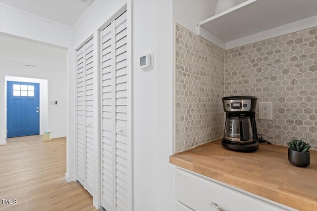 hall featuring crown molding and light hardwood / wood-style flooring