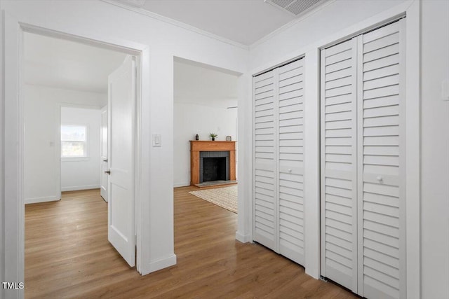 corridor featuring crown molding and light wood-type flooring