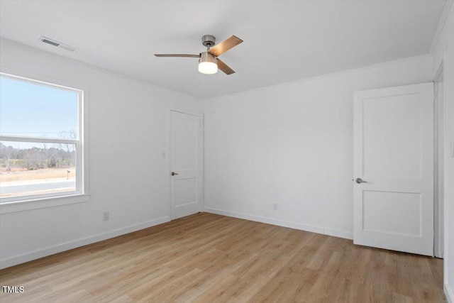 empty room with ceiling fan, ornamental molding, and light hardwood / wood-style flooring