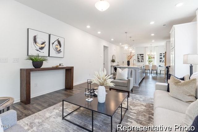 living room featuring dark hardwood / wood-style flooring, sink, and an inviting chandelier