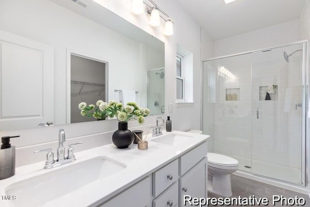 bathroom featuring vanity, toilet, and walk in shower