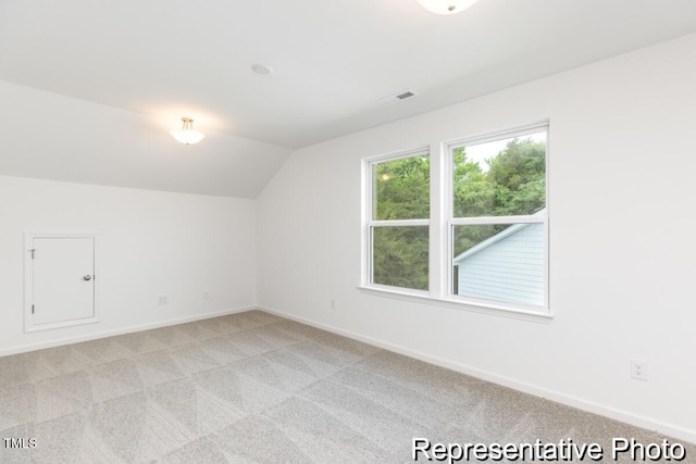 bonus room featuring vaulted ceiling and light carpet