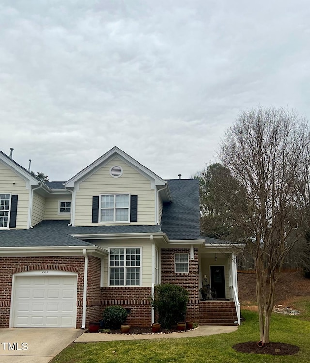 traditional-style house featuring brick siding, a shingled roof, concrete driveway, a front yard, and an attached garage