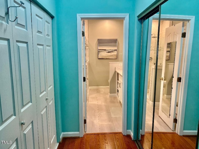 corridor with baseboards and wood finished floors