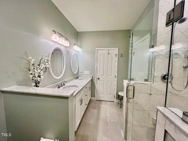 bathroom with a sink, a shower stall, and double vanity