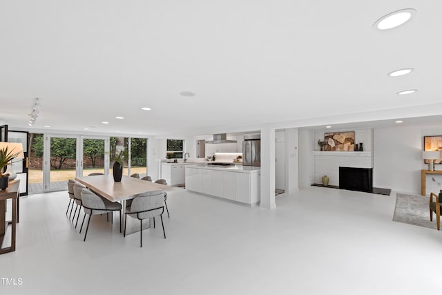 dining area with floor to ceiling windows, a fireplace, and sink