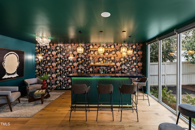 bar featuring hanging light fixtures and light wood-type flooring