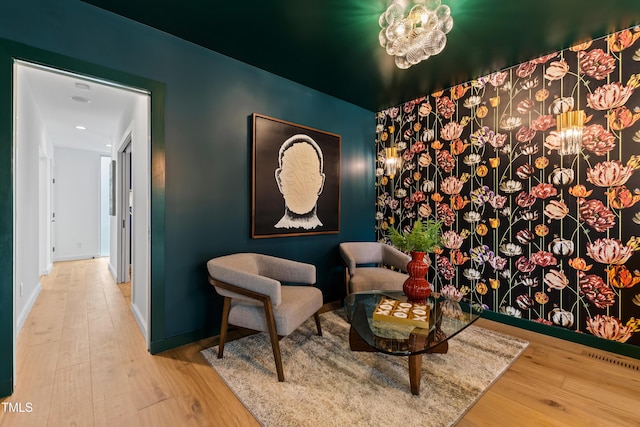 living area with hardwood / wood-style floors and a chandelier