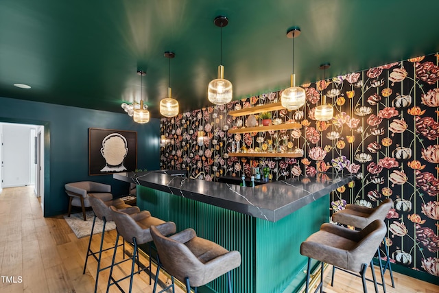 bar featuring decorative light fixtures and light wood-type flooring