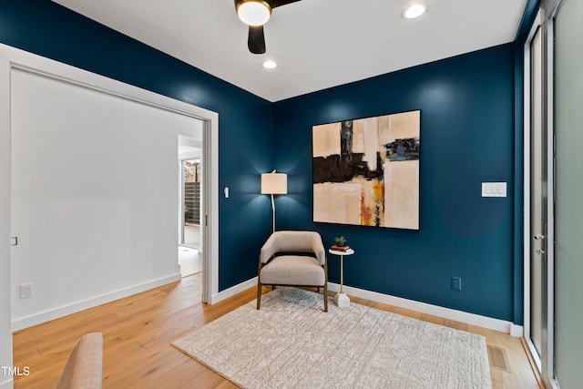 living area with hardwood / wood-style flooring and ceiling fan