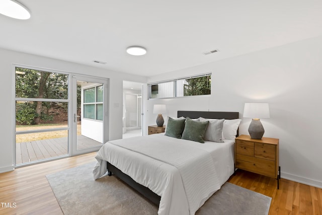 bedroom featuring wood-type flooring and access to outside