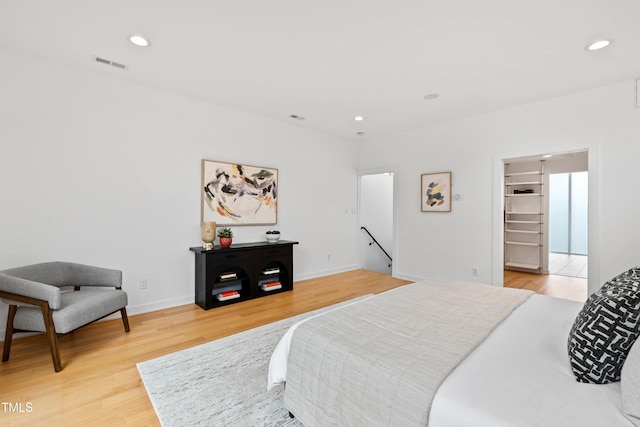 bedroom featuring hardwood / wood-style flooring and a spacious closet