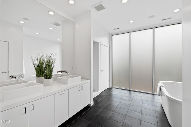 bathroom with vanity, a bath, and tile patterned floors