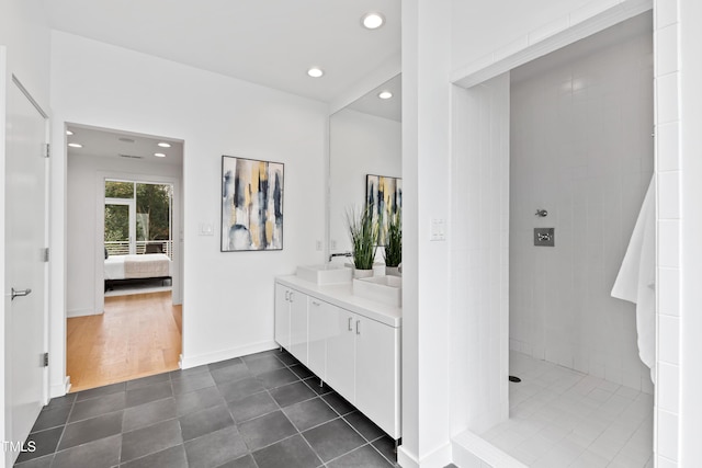 bathroom with tile patterned flooring, vanity, and tiled shower