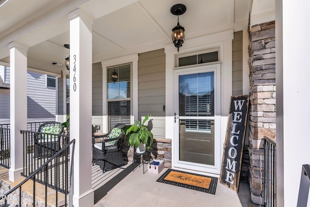 doorway to property with covered porch and stone siding