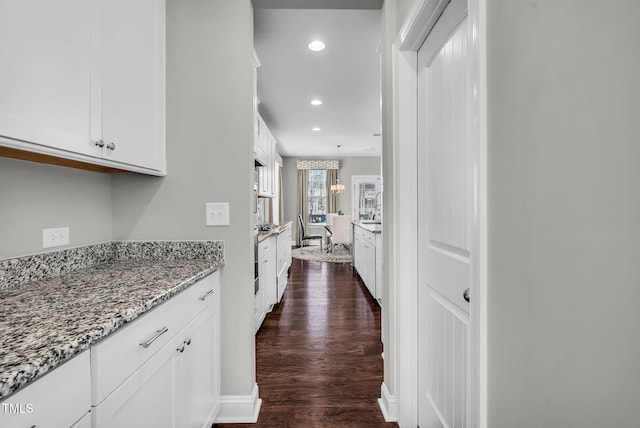 corridor with baseboards, dark wood finished floors, and recessed lighting