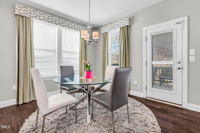 dining space featuring a chandelier, wood finished floors, and baseboards