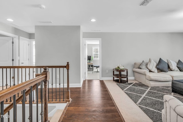 living area featuring recessed lighting, dark wood-style flooring, visible vents, and baseboards