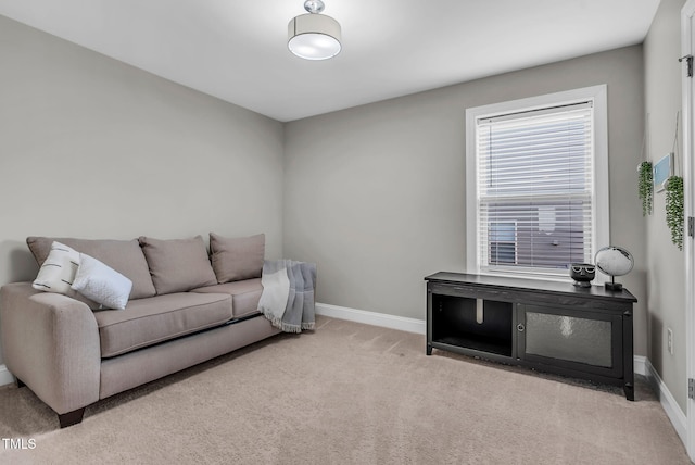 living area featuring baseboards and light colored carpet