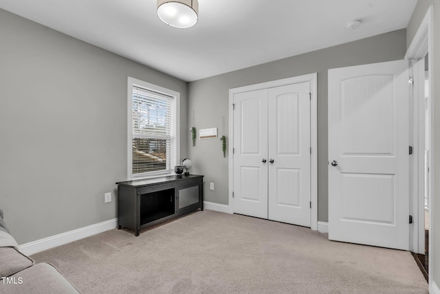 interior space featuring light carpet, baseboards, and a closet