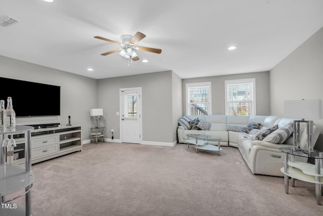 living room with visible vents, plenty of natural light, and light carpet