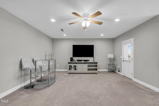 living area with baseboards, visible vents, and light colored carpet