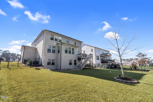 back of property featuring stairs, fence, a lawn, and a wooden deck