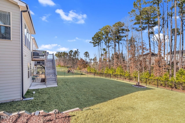 view of yard featuring a fenced backyard, stairs, and a deck