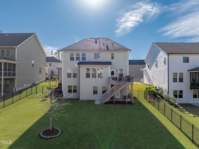 back of house with a deck, a fenced backyard, a lawn, and stairway