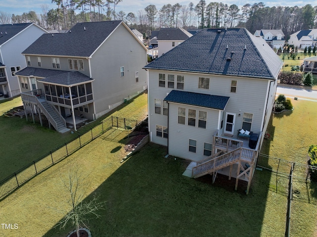 back of property with a deck, a fenced backyard, a sunroom, stairs, and a yard