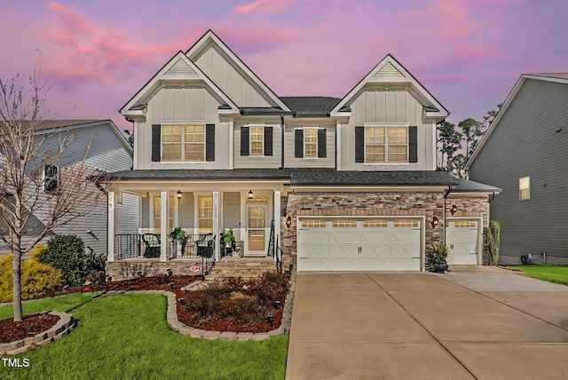 craftsman inspired home with a garage, concrete driveway, covered porch, a yard, and board and batten siding