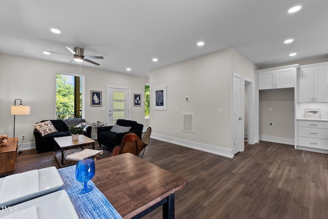 living room with dark wood-type flooring and ceiling fan