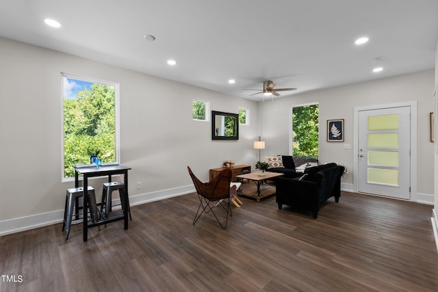 living room featuring ceiling fan and dark hardwood / wood-style flooring