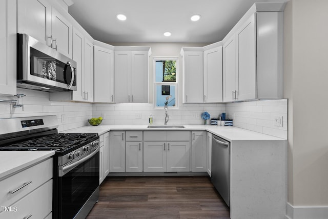 kitchen featuring sink, dark wood-type flooring, white cabinets, and appliances with stainless steel finishes