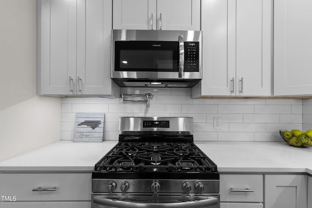 kitchen featuring light stone counters, white cabinetry, and stainless steel appliances