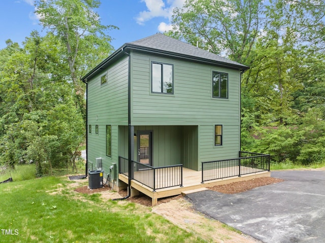 back of house with a lawn and central air condition unit