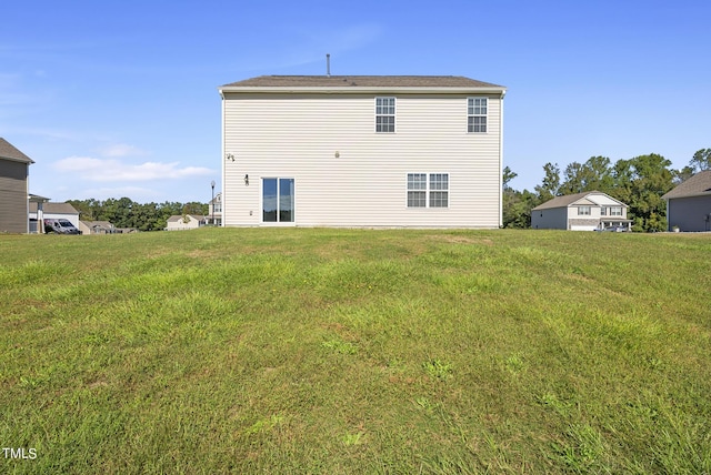 rear view of property featuring a yard