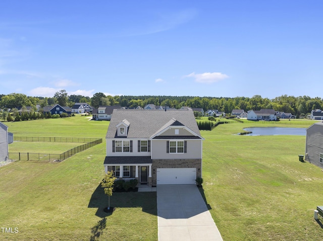 view of front of house with a front lawn, a water view, fence, concrete driveway, and a garage