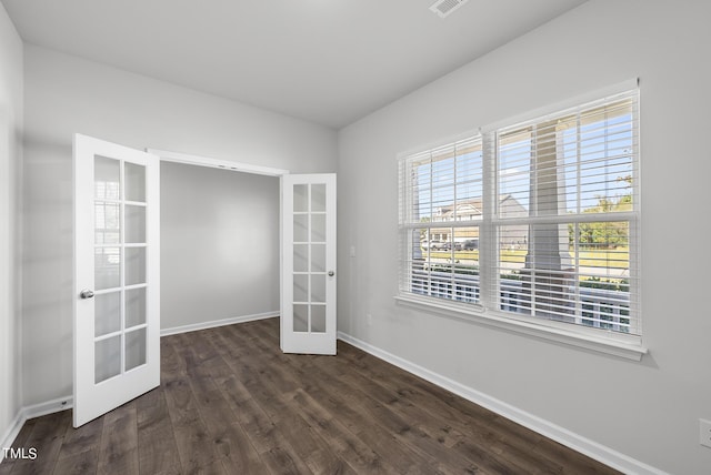 spare room with french doors, baseboards, and dark wood-style floors