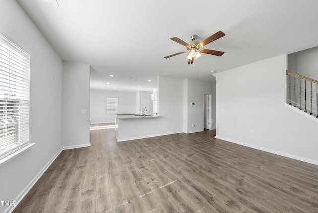 unfurnished living room featuring recessed lighting, wood finished floors, baseboards, and ceiling fan