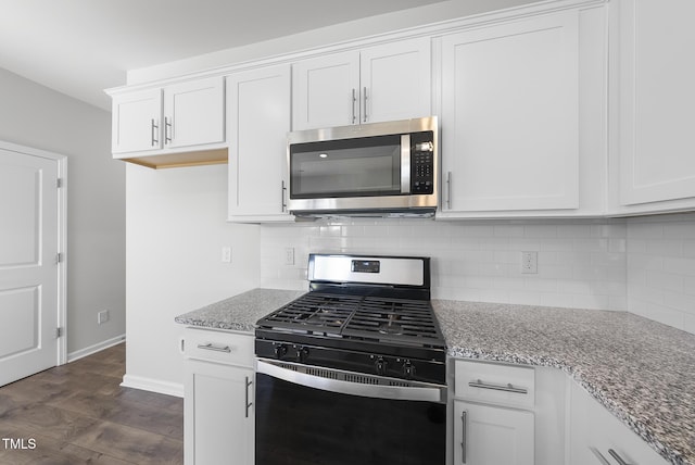 kitchen featuring light stone counters, tasteful backsplash, dark wood-style flooring, and stainless steel appliances