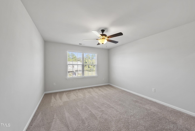 empty room featuring ceiling fan, baseboards, and light carpet