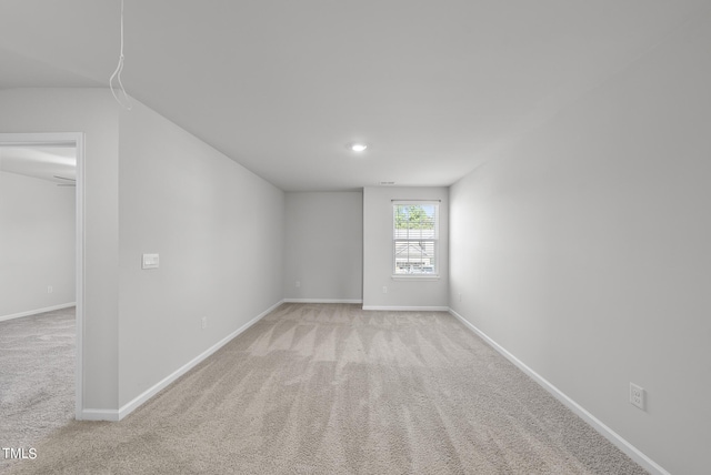 spare room with baseboards and carpet floors