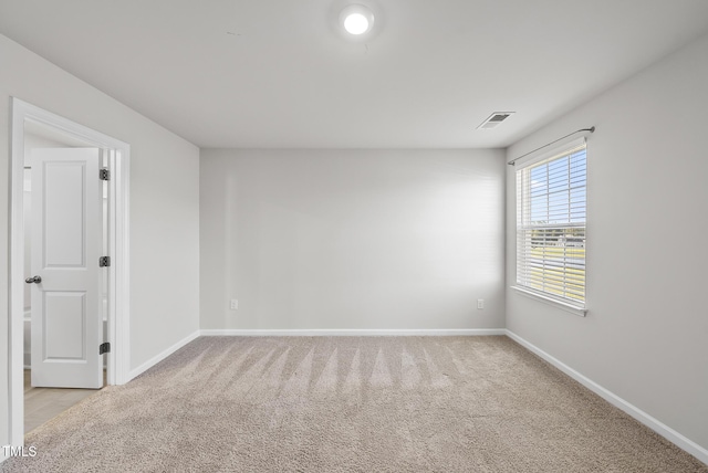 unfurnished room featuring light carpet, visible vents, and baseboards