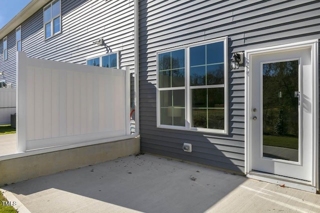 view of side of property with a patio and central air condition unit